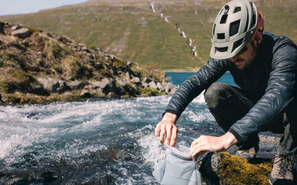 Cyclist refilling a hydration bladder at a water station