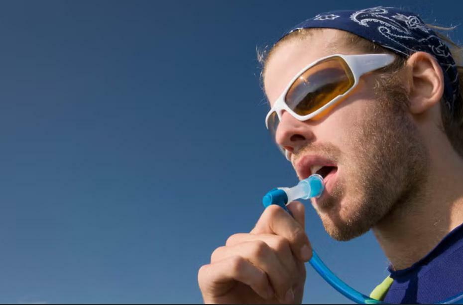 Hiker drinking from a clean hydration bladder on a trail